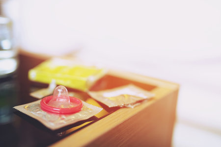 Condoms ready to using in female hand, give condom safe sex concept on the bed Prevent infection and Contraceptives control the birth rate or safe prophylactic. World AIDS Day, Leave space for text.の写真素材