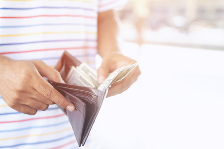 Businessman Person holding an wallet in the hands of an man take money out of pocket.の写真素材