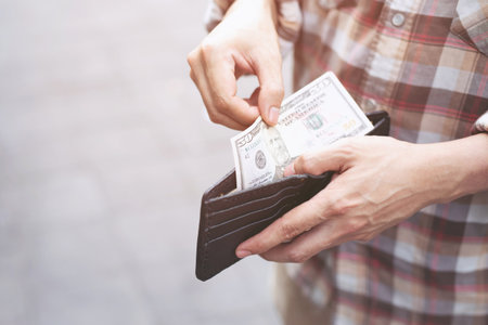 Businessman Person holding an wallet in the hands of an man take money out of pocket.の写真素材