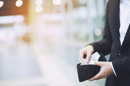 Businessman Person holding an wallet in the hands of an man take money out of pocket.の写真素材