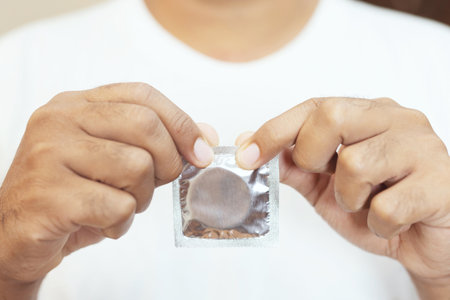 Condom ready to use in female hand, give condom safe sex concept on the bed Prevent infection and Contraceptives control the birth rate or safe prophylactic. World AIDS Day, Leave space for text.の写真素材