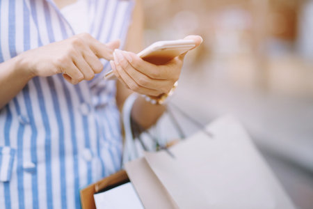 Close up of consumerism young woman holding hand many shopping bag in fashion boutique after buying presents while walking along the street with copy space , enjoying summer sale and people conceptの写真素材