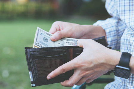 Businessman Person holding an wallet in the hands of an man take money out of pocket.の写真素材
