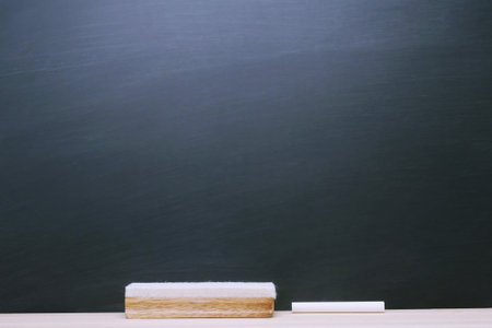 Blank Dark blackboard with Chalk and eraser on the frame for drawing in Classroom. Horizontal composition. copy space empty Chalkboard Background. back to school.の写真素材
