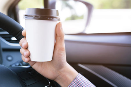 people person drinking paper cup coffee of hot in hand while driving in a car in the morning .transportation and vehicle concept.の写真素材