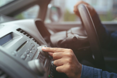 close up hand open car radio listening. Car Driver changing turning button Radio Stations on His Vehicle Multimedia System. Modern touch screen Audio stereo System. transportation and vehicle conceptの写真素材