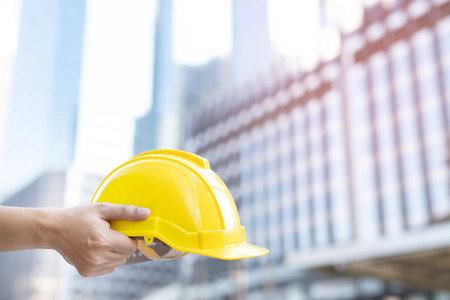 Close up front view of engineering male construction worker stand holding safety white helmet and...