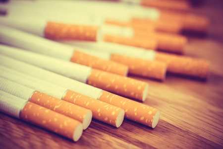 image of several commercially made cigarettes. pile cigarette on wooden. or Non smoking campaign concept, tobacco. filter vintage retro.の写真素材