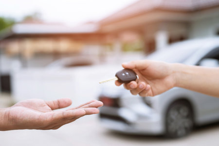 Car key, businessman handing over gives the car key to the other man on car window background. Leave space to write messages.の写真素材