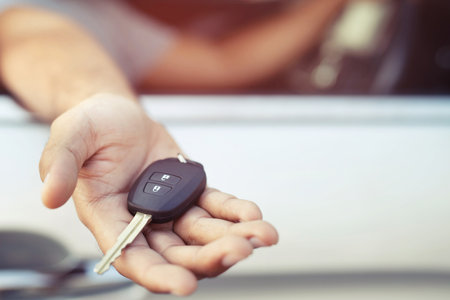 businessman handing over gives the car key to the other man interior in car. Leave space to write a description of the message.の写真素材