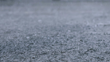 Rain drops in the water heavy on asphalt shade of black shadow and reflection of dark sky in the city. high contrast during autumnの写真素材