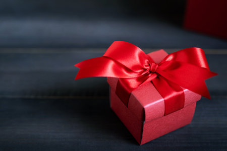 gift box white new year or Christmas Packed present container with red ribbon on Vintage wooden...