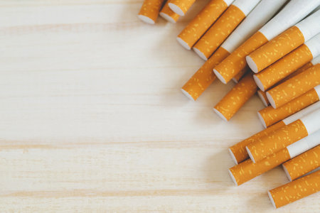 image of several commercially made pile cigarette on white wooden background. or Non smoking campaign concept, tobacco pattern top view.の写真素材