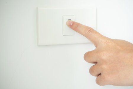 Turn off the light, close up man hand is closing the power switch.