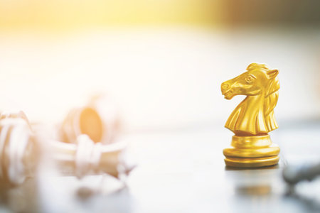golden chess horse moving on a chessboard game fallen silver color tone victory success. strategy ideas Planning and Decision concept business leader.の写真素材
