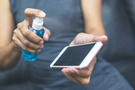 A man is using spray clean mobile phoneの写真素材