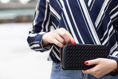 A woman carrying a wallet while shopping at a mall