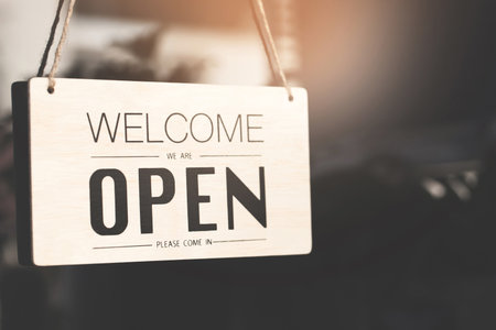 A business sign that says â€˜Openâ€™ on cafe or restaurant hang on door