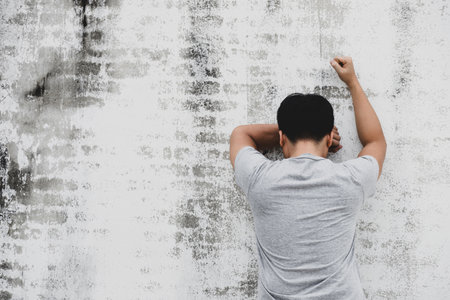 Portrait of a sad man facing a wall