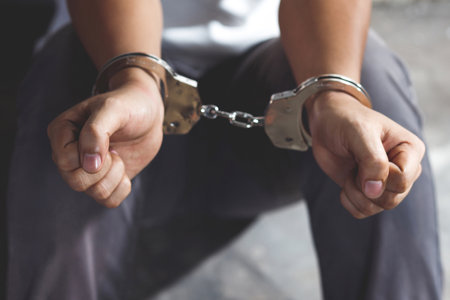 Handcuffed prisoner in jail