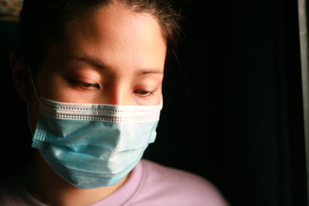 Woman wearing a mask and detained for 14 days at home because she is infected with COVID 19.の写真素材