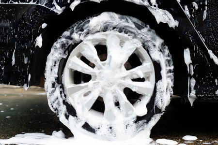 car wash with active foam soap. cleaning wheel tire. commercial cleaning service concept.の写真素材