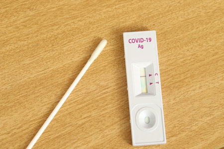 Covid-19 test kit laying on a wooden table