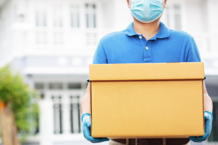 An employee holding a box is delivering products to customers home.の写真素材