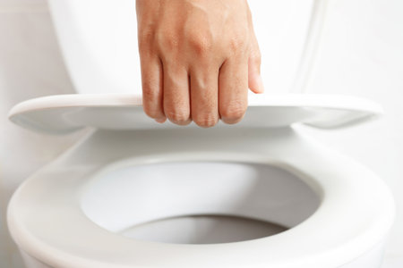 man's hand opening the toilet lidの写真素材
