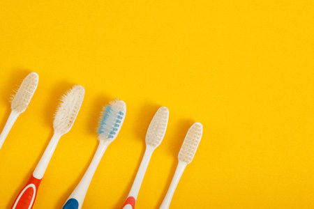 old toothbrush on yellow backgroundの写真素材