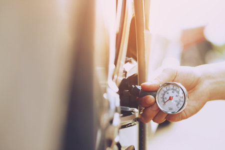close up hand man car parking a check and inflate the tire fill up the air for safe driving on the go. Transportation travel vehicle concept.の写真素材