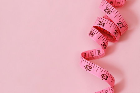 tape measure for obese people on a pink background soft focus