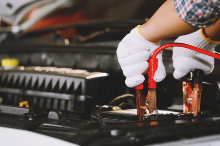 A mechanic  is charging car battery potの写真素材