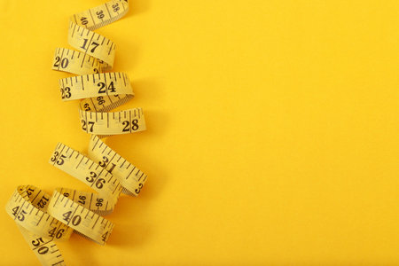tape measure for obese people on a yellow background soft focus