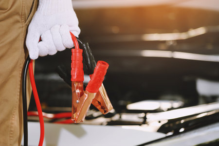 A mechanic  is charging car battery pot