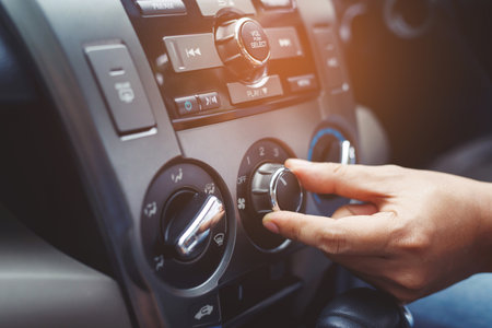 Closeup of hand driver man checking switch adjusting air from conditioning the cooling system with flow of cold in car. Leave space for writing text.の写真素材