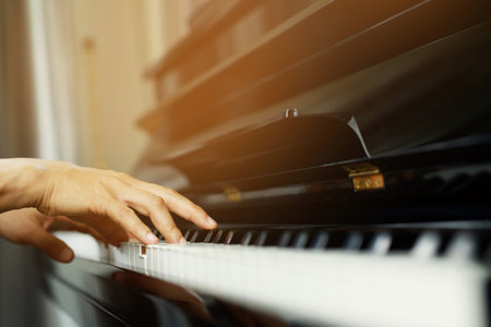 close up of hand people man musician playing piano keyboard with selective focus keys. can be used as a background.の写真素材