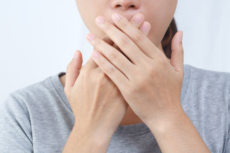 Asian woman checking her breath with hand test. Health Care concept.の写真素材