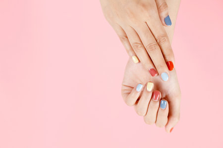 Beautiful female hand painting acrylic gel nails. Fashion style. Pink background.の写真素材