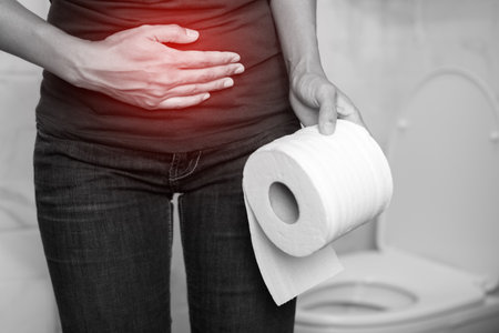 portrait of a woman suffers from diarrhea his stomach painful. ache and problem. hand hold tissue paper roll in front of toilet bowl. constipation in bathroom. Hygiene, health care concept.の写真素材