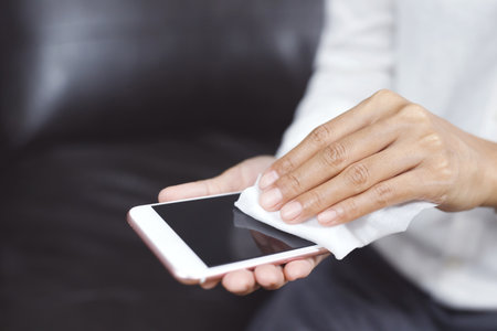 woman using tissue paper Clean your phone to remove germs.の写真素材