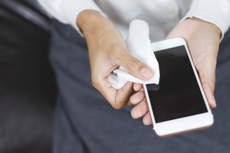 woman using tissue paper Clean your phone to remove germs.の写真素材