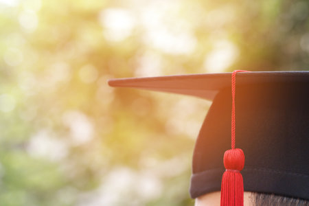 graduate are celebrating graduation. Happiness feeling hand hold show hat and diploma certificate in background sky.  Congratulation education during Commencement day University Degree.の写真素材