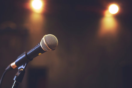 Close up of microphone on stage lighting at concert hall or conference room. copy space banner. soft focus.の写真素材