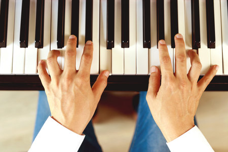 close up of hand people man musician playing piano keyboard with selective focus keys. can be used as a background.の写真素材