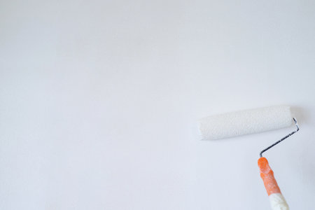 Roller Brush Painting, Worker painting on surface wall  Painting apartment, renovating with white color  paint. Leave empty copy space to write descriptive text beside.の写真素材
