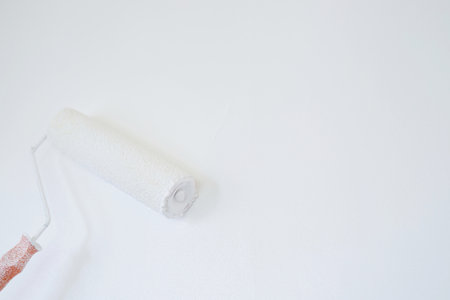 Roller Brush Painting, Worker painting on surface wall  Painting apartment, renovating with white color  paint. Leave empty copy space to write descriptive text beside.の写真素材