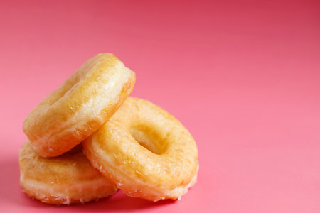 assorted donuts with chocolate frosting, topping sprinkles donuts Colorful variety and Variety of flavors mix of multi colored sweet donuts with frosted sprinkled on pink background. top viewの写真素材