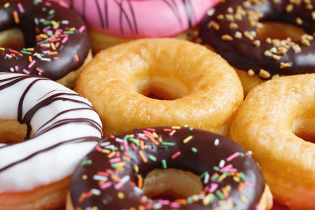 assorted donuts with chocolate frosting, topping sprinkles donuts Colorful variety and Variety of flavors mix of multi colored sweet donuts with frosted sprinkled on pink background. top viewの写真素材