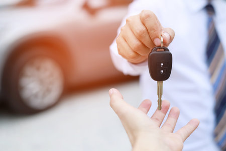 Car key, businessman handing exchange over give to the other man on showroom background. Seller dealer credit Interest payment or purchase by installment car concept.の写真素材